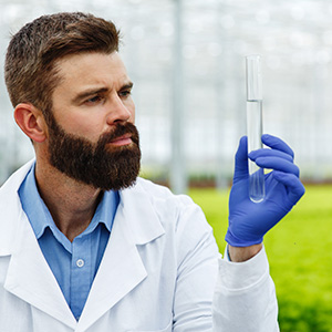 hombre-investigador-sostiene-tubo-vidrio-muestra-pie-antes-plantas-invernadero
