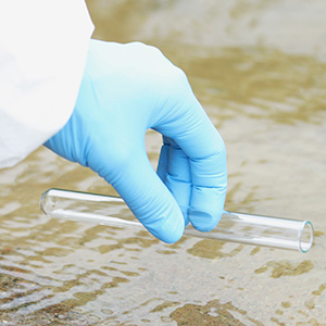 mano-cientifico-traje-protector-guante-hace-que-agua-tome-agua-lago-concepto-muestras-agua